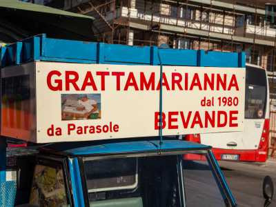 Subito risalta agli occhi il suo Ape azzurro, su cui sono apposte le scritte che riportano i nomi di �Grattamarianna� e �Parasole�
